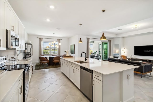 kitchen with plenty of natural light, appliances with stainless steel finishes, a sink, light tile patterned floors, and open floor plan
