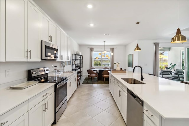 kitchen featuring light countertops, a sink, white cabinets, and stainless steel appliances