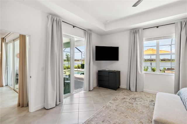 bedroom with baseboards, light tile patterned floors, and access to exterior