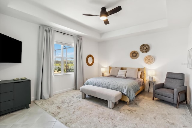 bedroom with a ceiling fan, baseboards, and a raised ceiling