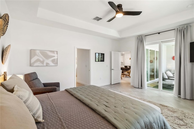 bedroom featuring ceiling fan, visible vents, access to exterior, light tile patterned floors, and a tray ceiling