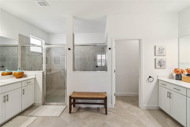 bathroom with visible vents, tile patterned flooring, a stall shower, vanity, and baseboards