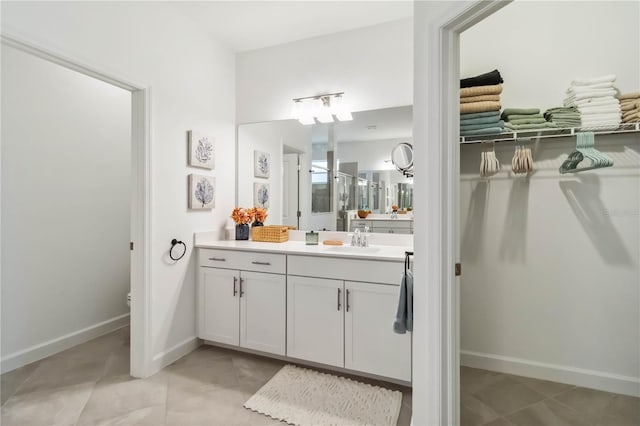 full bath with vanity, baseboards, and tile patterned floors