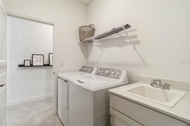laundry area with a sink, baseboards, cabinet space, and washer and clothes dryer