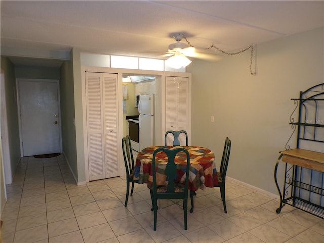dining area with light tile patterned floors, baseboards, and ceiling fan