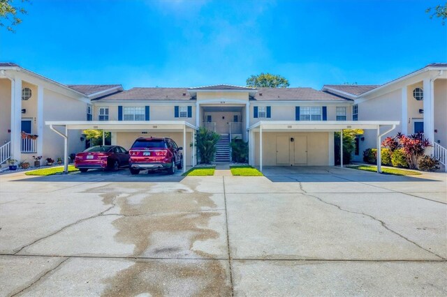 819 Montrose Dr Unit 102, Venice, FL 34293 - view of front of home with stucco siding, concrete driveway, and stairway