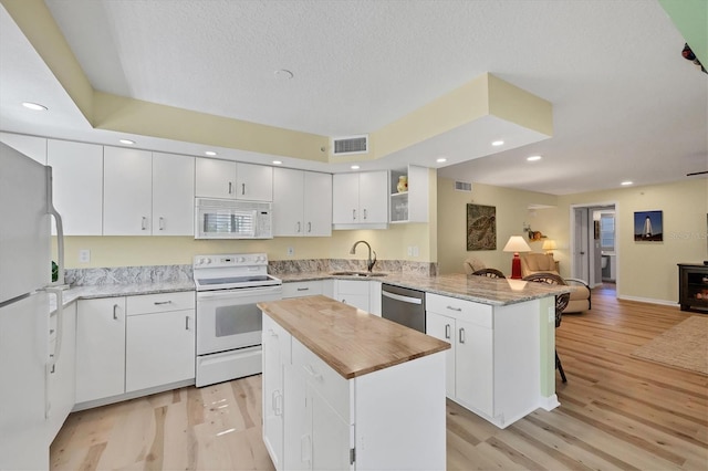819 Montrose Dr Unit 102, Venice, FL 34293 - kitchen featuring visible vents, a peninsula, white appliances, open floor plan, and a sink