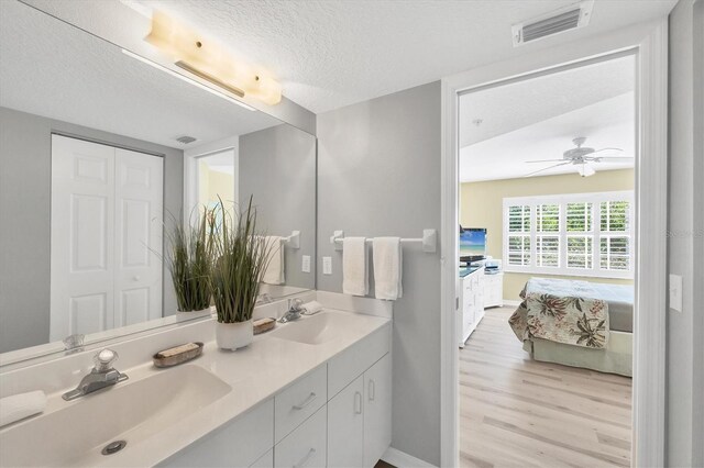 819 Montrose Dr Unit 102, Venice, FL 34293 - ensuite bathroom with visible vents, a sink, connected bathroom, and wood finished floors