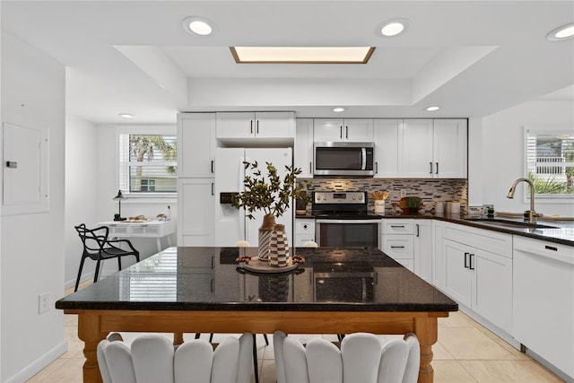 5031 N Beach Rd Unit 118, Englewood, FL 34223 - kitchen with appliances with stainless steel finishes, backsplash, plenty of natural light, white cabinets, and recessed lighting