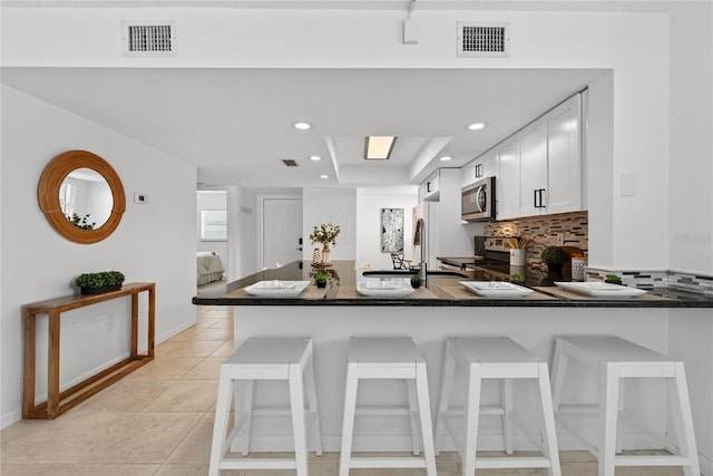 5031 N Beach Rd Unit 118, Englewood, FL 34223 - kitchen with appliances with stainless steel finishes, a peninsula, a breakfast bar, backsplash, and recessed lighting