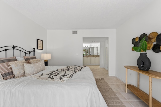 5031 N Beach Rd Unit 118, Englewood, FL 34223 - bedroom with light tile patterned floors and ensuite bath