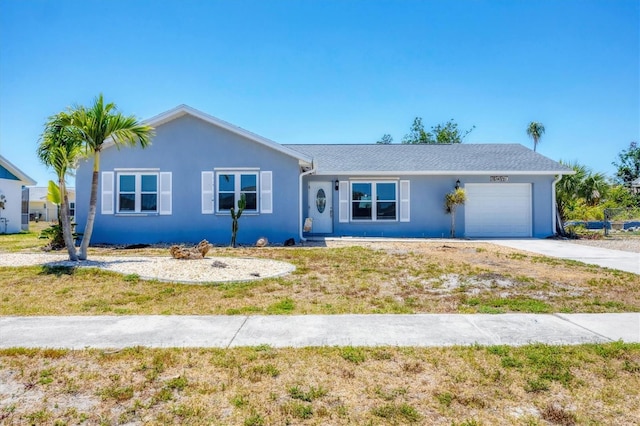 single story home with concrete driveway, an attached garage, and stucco siding