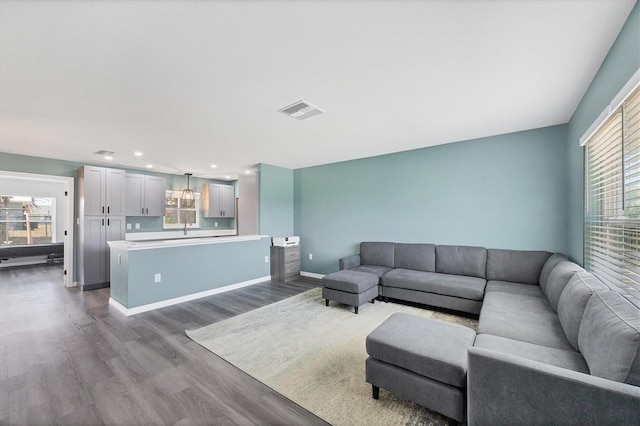 living area featuring recessed lighting, baseboards, dark wood-style floors, and visible vents