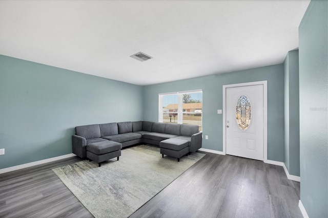 living area featuring visible vents, baseboards, and wood finished floors