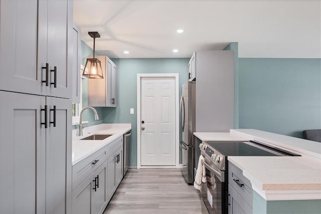 clothes washing area with laundry area, a sink, light wood-style floors, recessed lighting, and washer and dryer