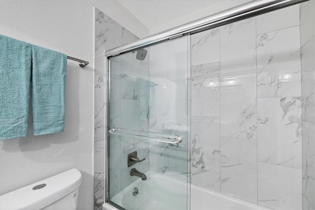 bathroom featuring bath / shower combo with glass door and toilet