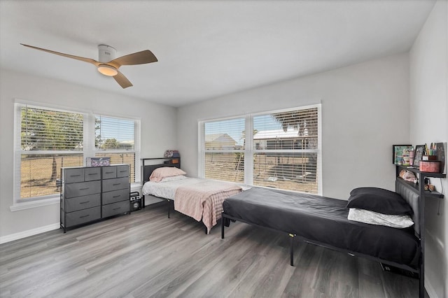 bedroom featuring baseboards, ceiling fan, and wood finished floors