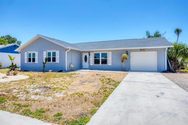 single story home with an attached garage, stucco siding, and driveway
