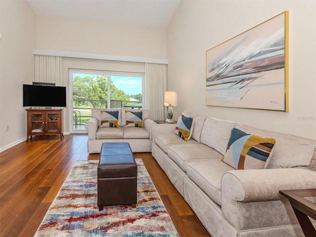 living room with baseboards, vaulted ceiling, and wood finished floors