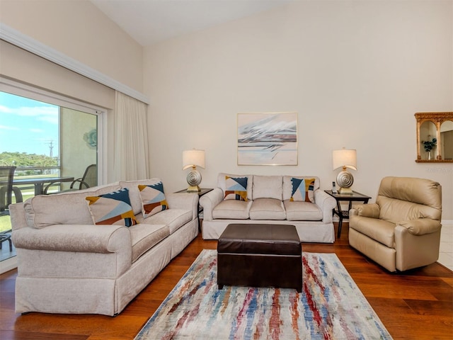 living area featuring wood finished floors and a towering ceiling