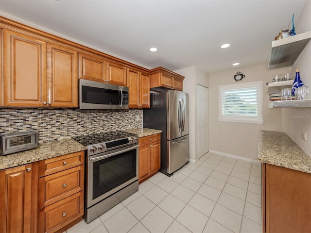 kitchen with brown cabinetry, backsplash, a toaster, and appliances with stainless steel finishes