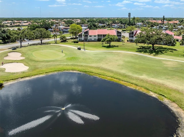 view of home's community featuring a water view, a yard, and golf course view