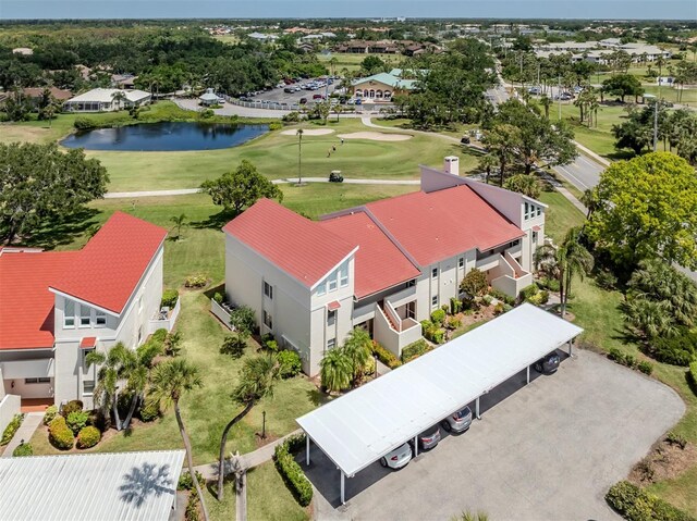 drone / aerial view with a water view and golf course view