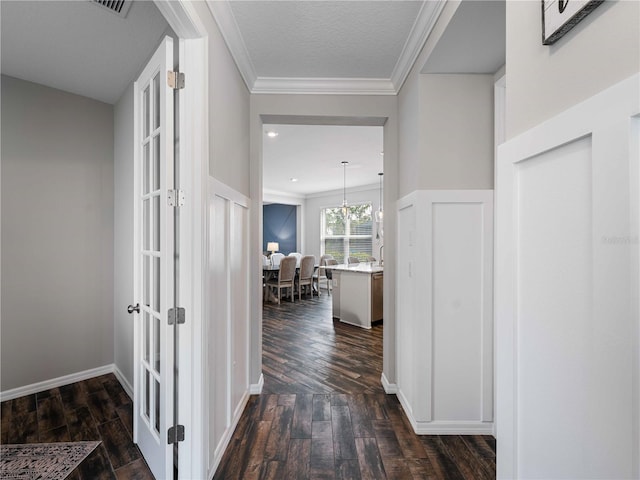 8304 Shooting Star Rd, Sarasota, FL 34241 - corridor featuring dark wood-type flooring, crown molding, french doors, and a chandelier