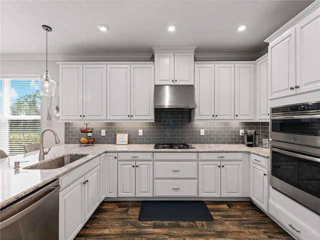 8304 Shooting Star Rd, Sarasota, FL 34241 - kitchen featuring stainless steel appliances, a sink, under cabinet range hood, white cabinets, and backsplash