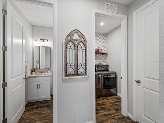 8304 Shooting Star Rd, Sarasota, FL 34241 - bathroom featuring washing machine and clothes dryer, wood finished floors, vanity, and backsplash