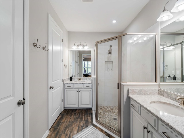 8304 Shooting Star Rd, Sarasota, FL 34241 - full bathroom with a stall shower, wood finished floors, two vanities, and recessed lighting