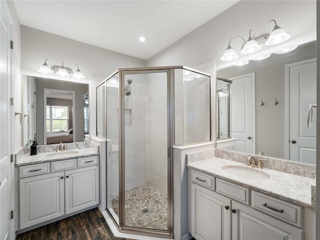 8304 Shooting Star Rd, Sarasota, FL 34241 - bathroom with a shower stall, ensuite bath, wood finished floors, and two vanities