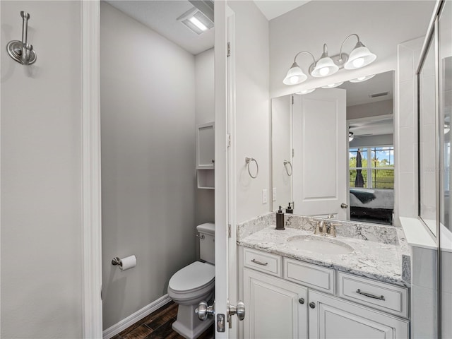 8304 Shooting Star Rd, Sarasota, FL 34241 - ensuite bathroom featuring toilet, wood finished floors, vanity, ceiling fan, and baseboards