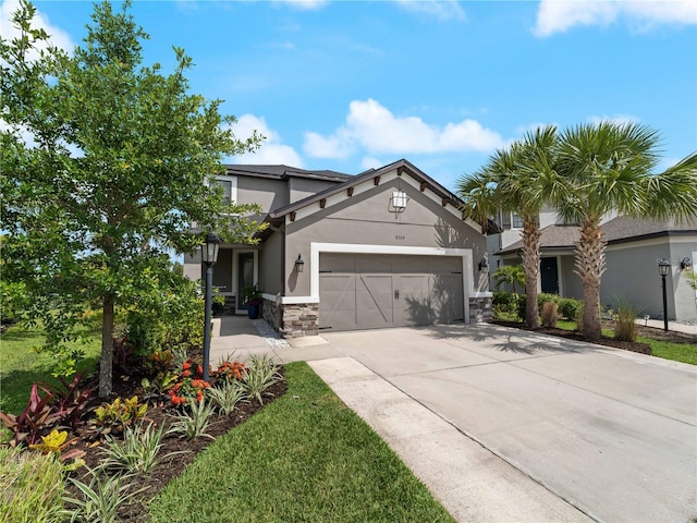8304 Shooting Star Rd, Sarasota, FL 34241 - view of front facade featuring stucco siding, a garage, concrete driveway, and stone siding