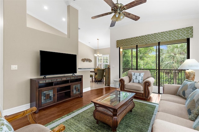 living room with crown molding, baseboards, wood finished floors, and vaulted ceiling