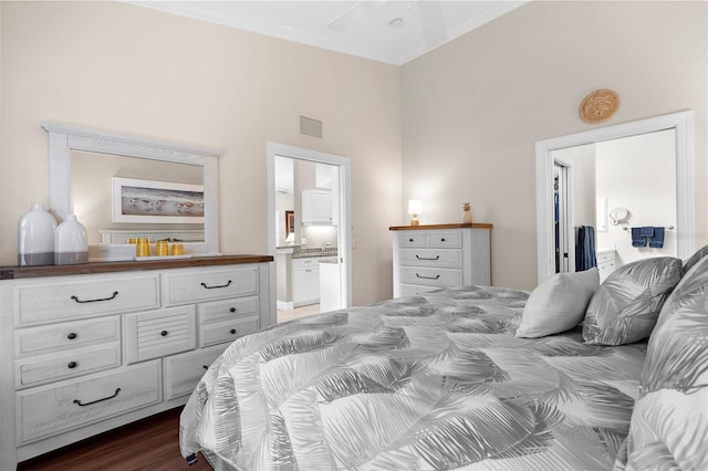 bedroom with visible vents, dark wood-style flooring, and ensuite bath