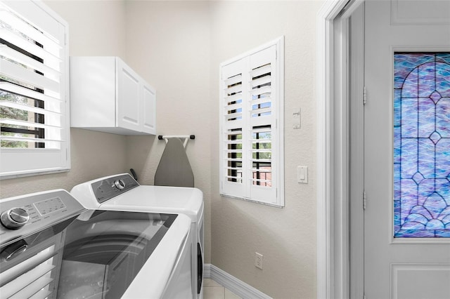 laundry area featuring separate washer and dryer, cabinet space, and a wealth of natural light