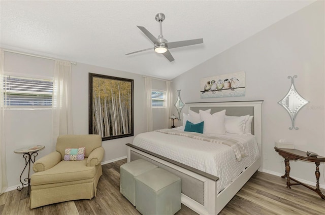 bedroom with a ceiling fan, baseboards, vaulted ceiling, and wood finished floors