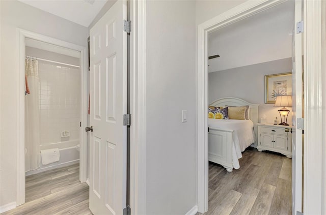 hallway featuring light wood-style floors and baseboards