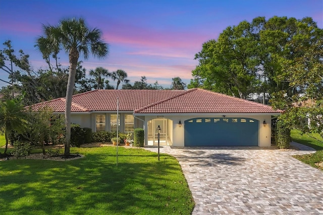 316 Signorelli Dr, Nokomis, FL 34275 - mediterranean / spanish house featuring an attached garage, decorative driveway, a lawn, and stucco siding