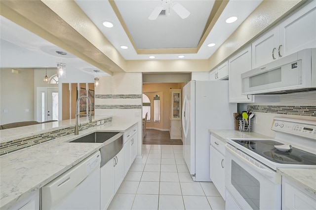 447 Rotonda Cir, Rotonda West, FL 33947 - kitchen with white appliances, a sink, tasteful backsplash, light tile patterned floors, and white cabinetry