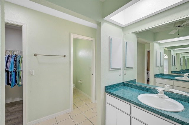 447 Rotonda Cir, Rotonda West, FL 33947 - full bath featuring toilet, vanity, a spacious closet, a ceiling fan, and tile patterned flooring
