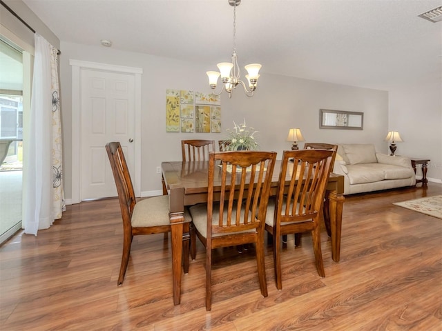 455 Rubens Dr E, Nokomis, FL 34275 - dining space featuring light wood-type flooring, a chandelier, and baseboards