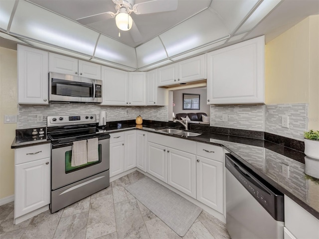 455 Rubens Dr E, Nokomis, FL 34275 - kitchen with appliances with stainless steel finishes, a sink, ceiling fan, white cabinets, and backsplash