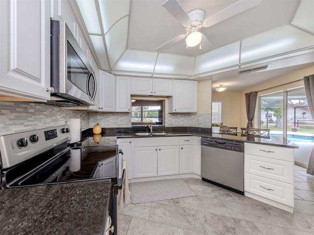 455 Rubens Dr E, Nokomis, FL 34275 - kitchen featuring appliances with stainless steel finishes, a sink, decorative backsplash, white cabinetry, and a ceiling fan