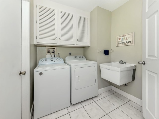 455 Rubens Dr E, Nokomis, FL 34275 - laundry room featuring cabinet space, washer and clothes dryer, light tile patterned floors, and baseboards