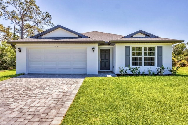 2032 Jagust Rd, North Port, FL 34288 - ranch-style house featuring decorative driveway, an attached garage, a front lawn, and stucco siding