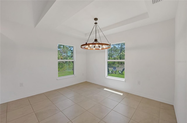 2032 Jagust Rd, North Port, FL 34288 - spare room featuring baseboards, a raised ceiling, light tile patterned floors, and a notable chandelier