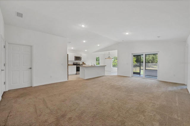 2032 Jagust Rd, North Port, FL 34288 - unfurnished living room with baseboards, visible vents, light colored carpet, and lofted ceiling