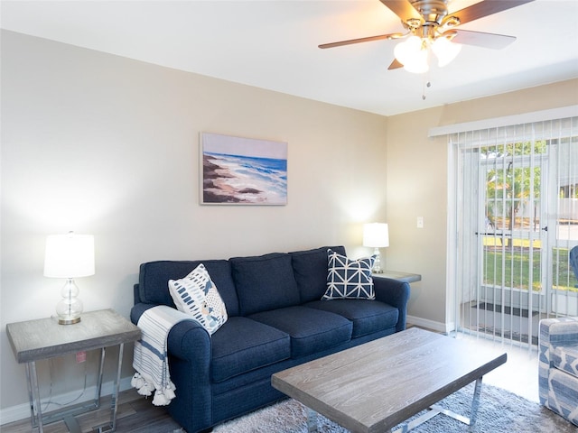 living room with baseboards and ceiling fan